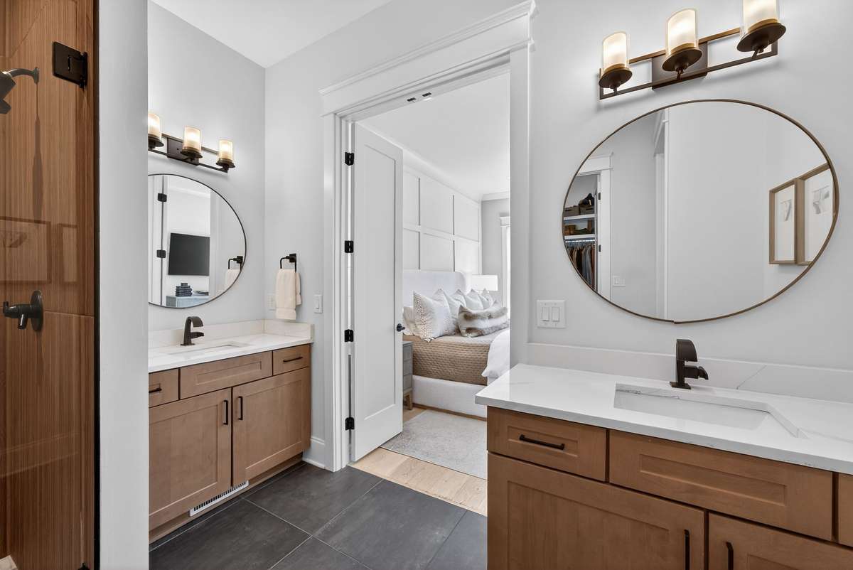 Spa-like primary bath featuring dual vanities and a sleek walk-in shower.