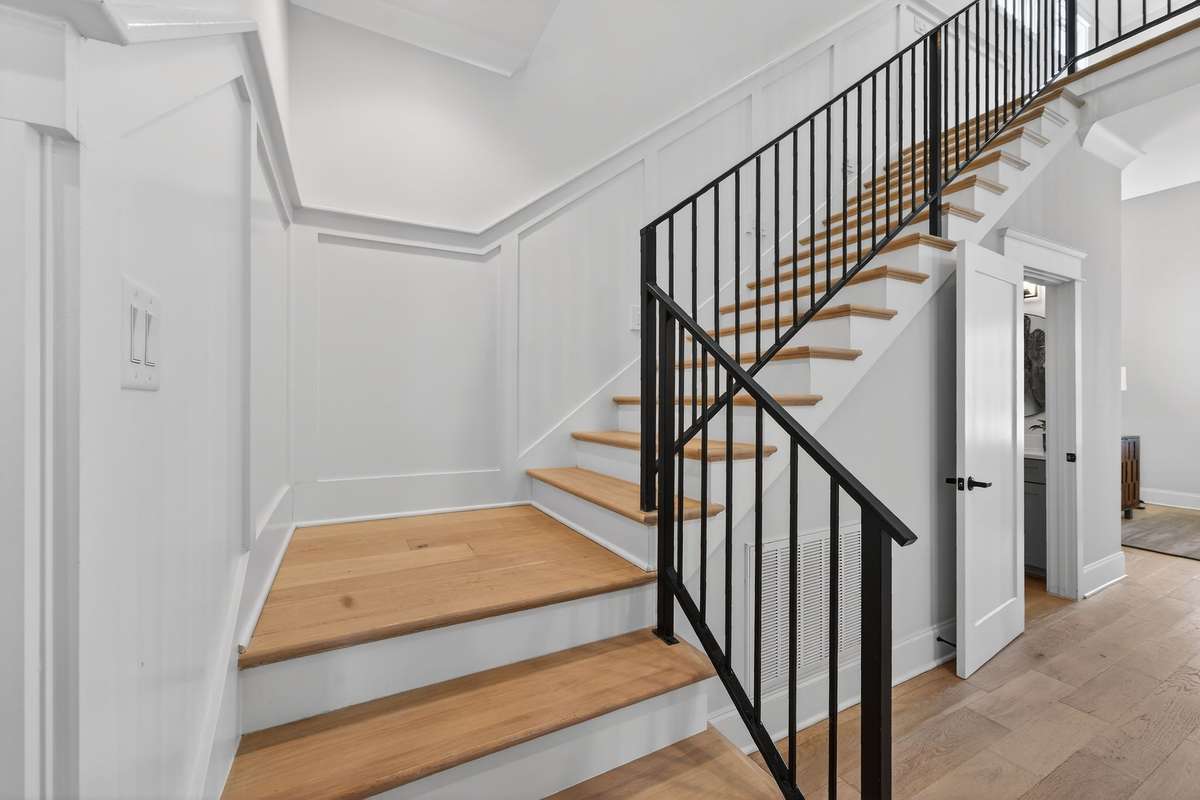 A statement staircase featuring custom millwork and sleek iron detailing.