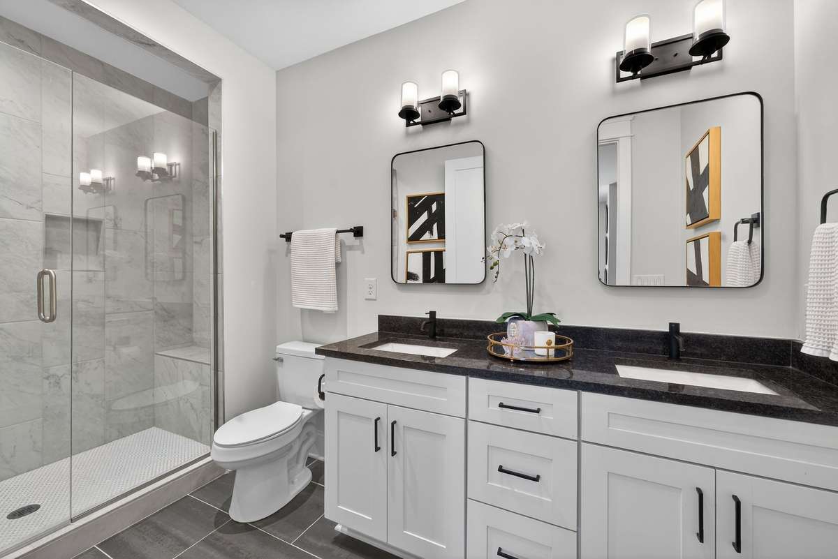 A beautifully finished bath with dual vanities and a walk-in shower.