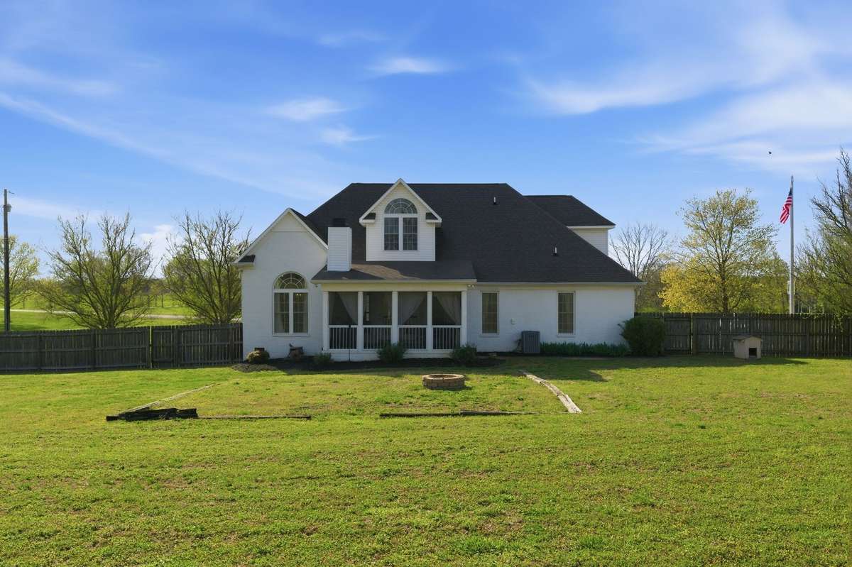 The expansive backyard includes a fenced garden area, perfect for protecting your summer plants from unwanted critters.