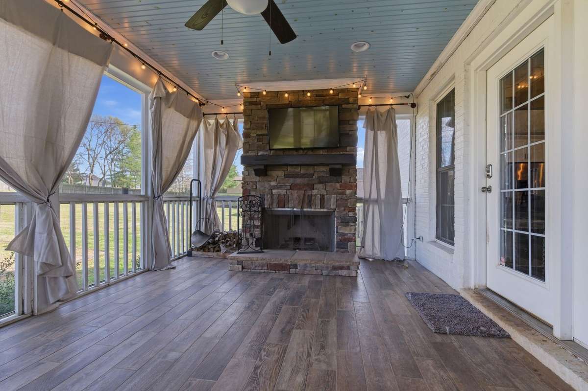 Enjoy cool fall football weekends on the screened-in back porch, complete with a wood-burning fireplace, TV, and ceiling fan—perfect for relaxing with friends.