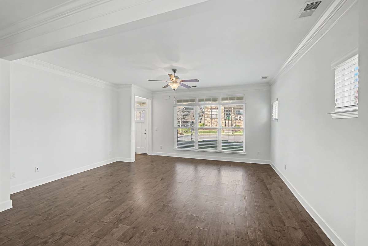Pristine condition this light filled living room with beautiful hardwood floors, crown molding and window treatments is sure to please.