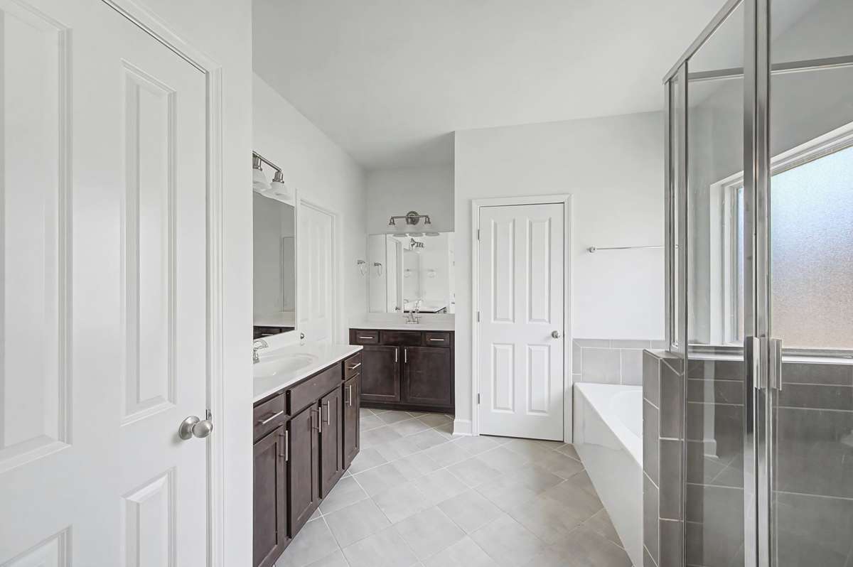 Separate vanities, large soaking tub and separate shower create a spa like atmosphere with natural light to relax or get ready for the day.