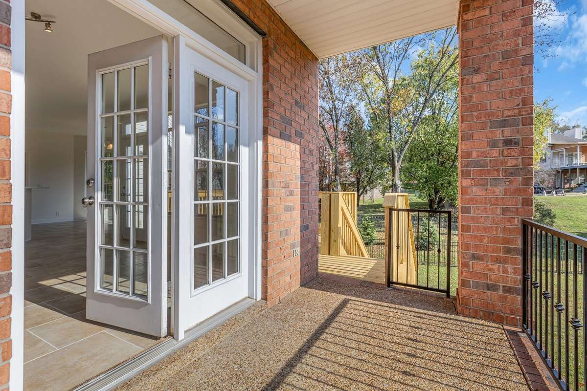 Covered Porch on side of house has a view of the backyard and driveway and access to the new deck.