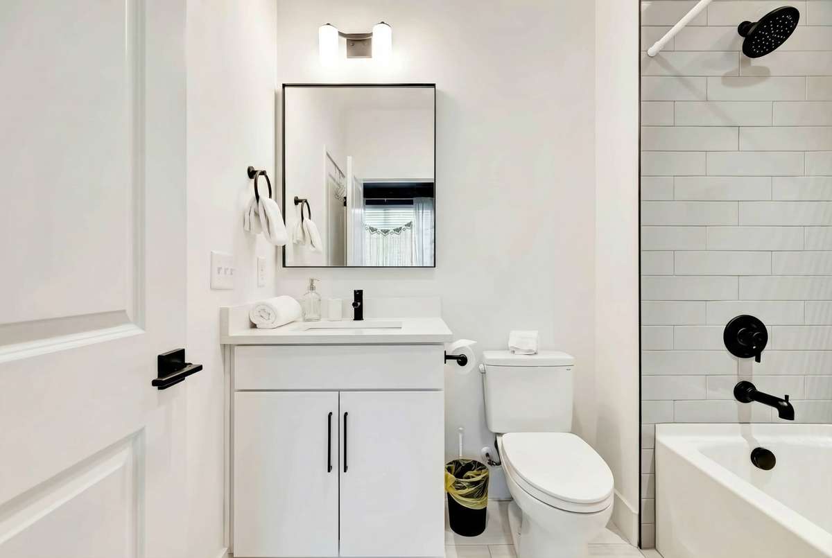The attached private bath includes a deep bathtub with an attractive gray tile surround.
