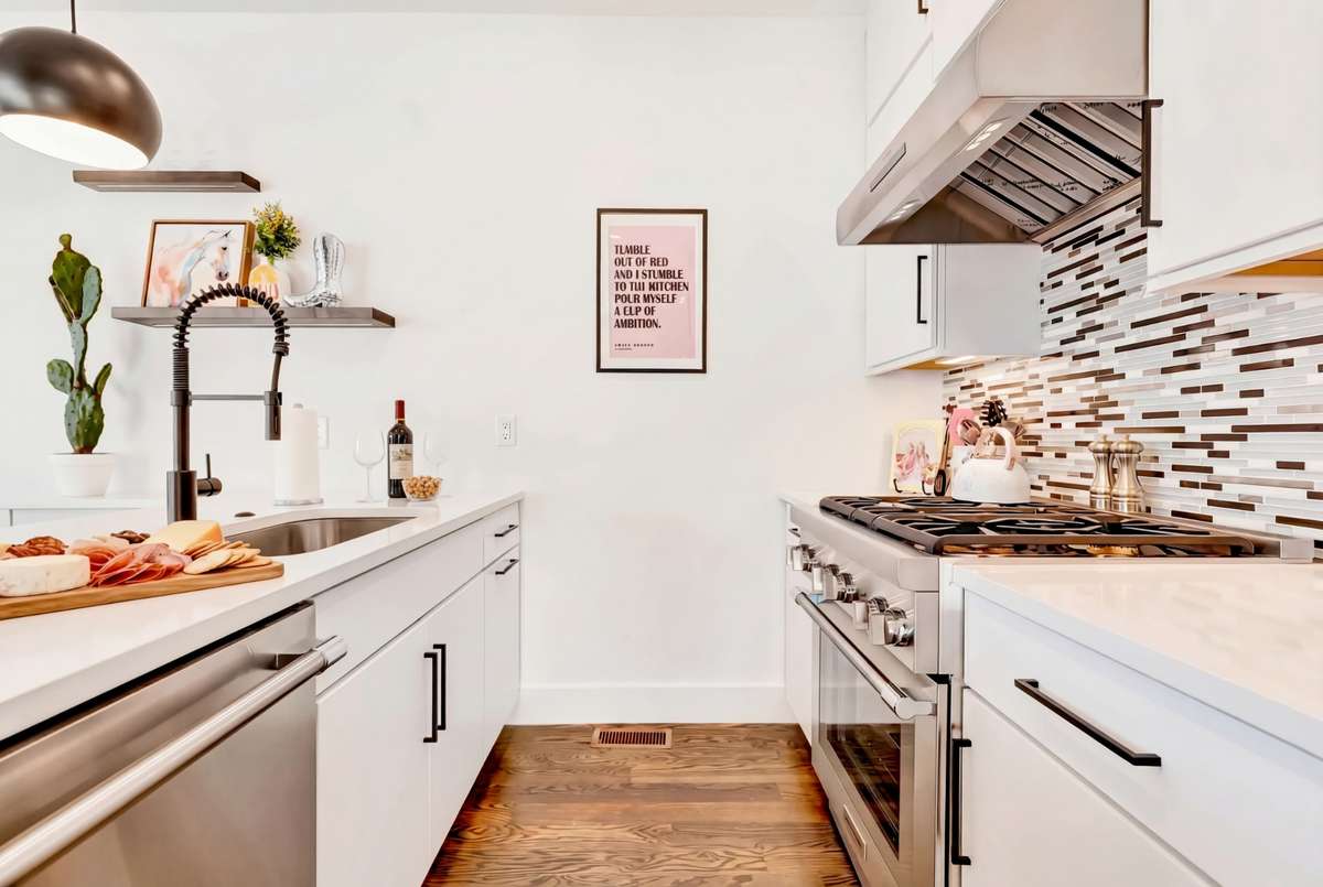 A custom backsplash frames the stainless steel gas range.