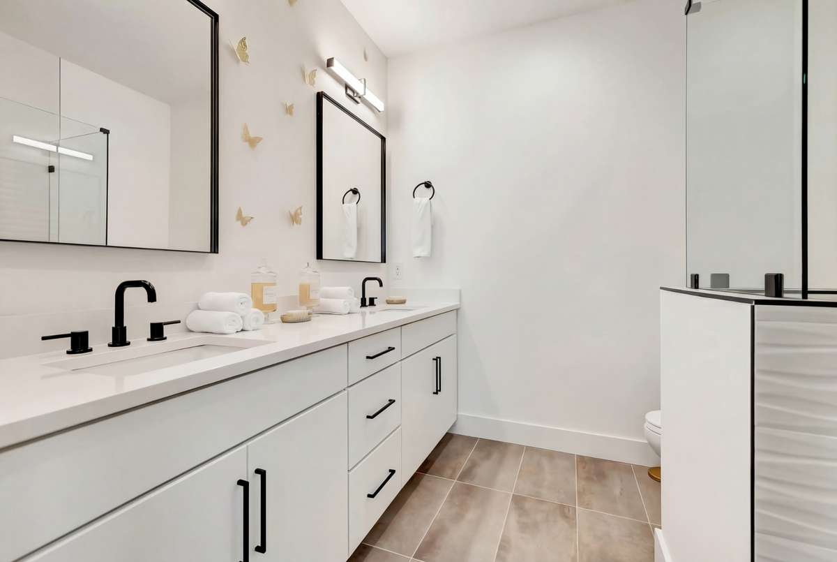 The attached bath features modern vanities with chic lighting and contemporary finishes.