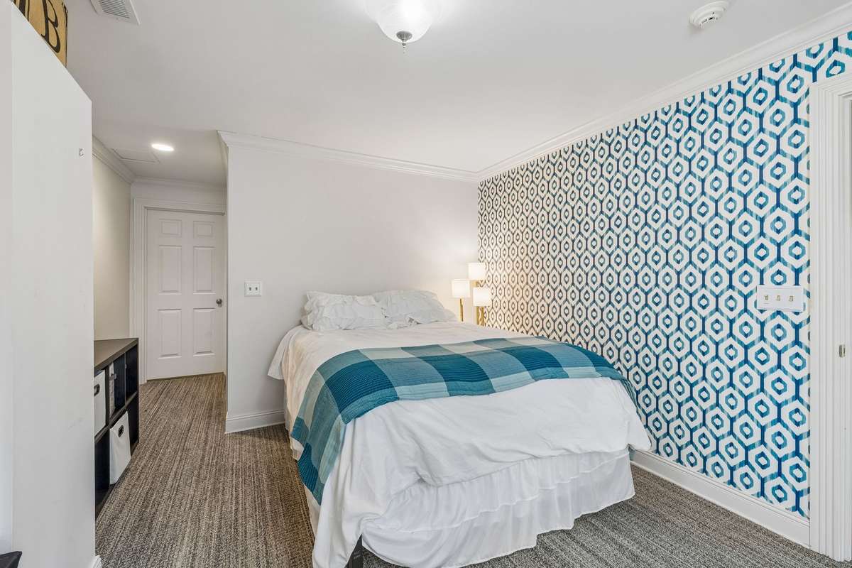 This lower level bedroom contains a walk in closet and access to a full bathroom.  There are windows overlooking the picturesque backyard setting.