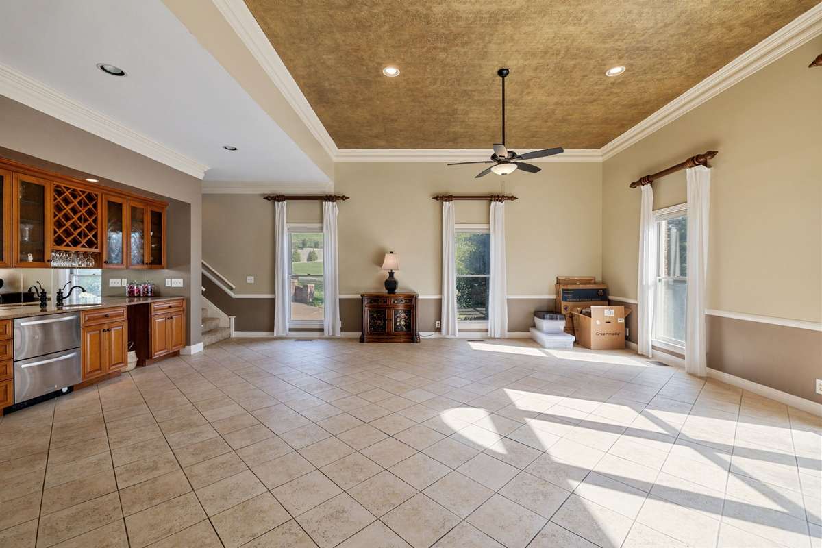 The wet bar in this room has a built in wine rack, a refrigerator door, freezer door, sink and space for an ice maker.