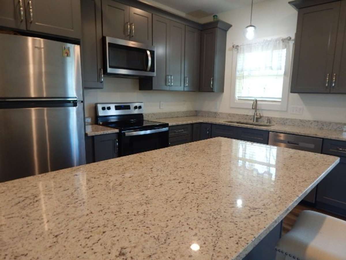 Stainless steel appliances include refrigerator, dishwasher, range and microwave.