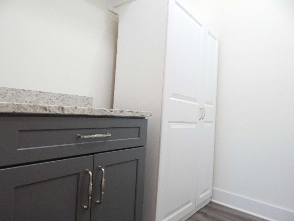 This utility room has a granite topped cabinet and another cabinet for storage. This room measures 8.9 x 6.7.