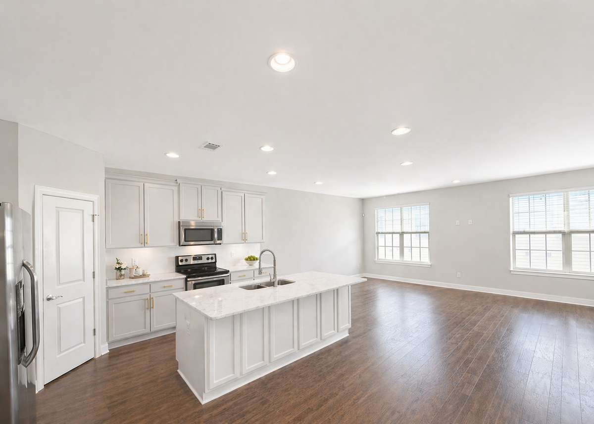 The Ashford’s bright, spacious kitchen features a large island and open layout designed for gathering and flow. (AI rendering based on previously built home)