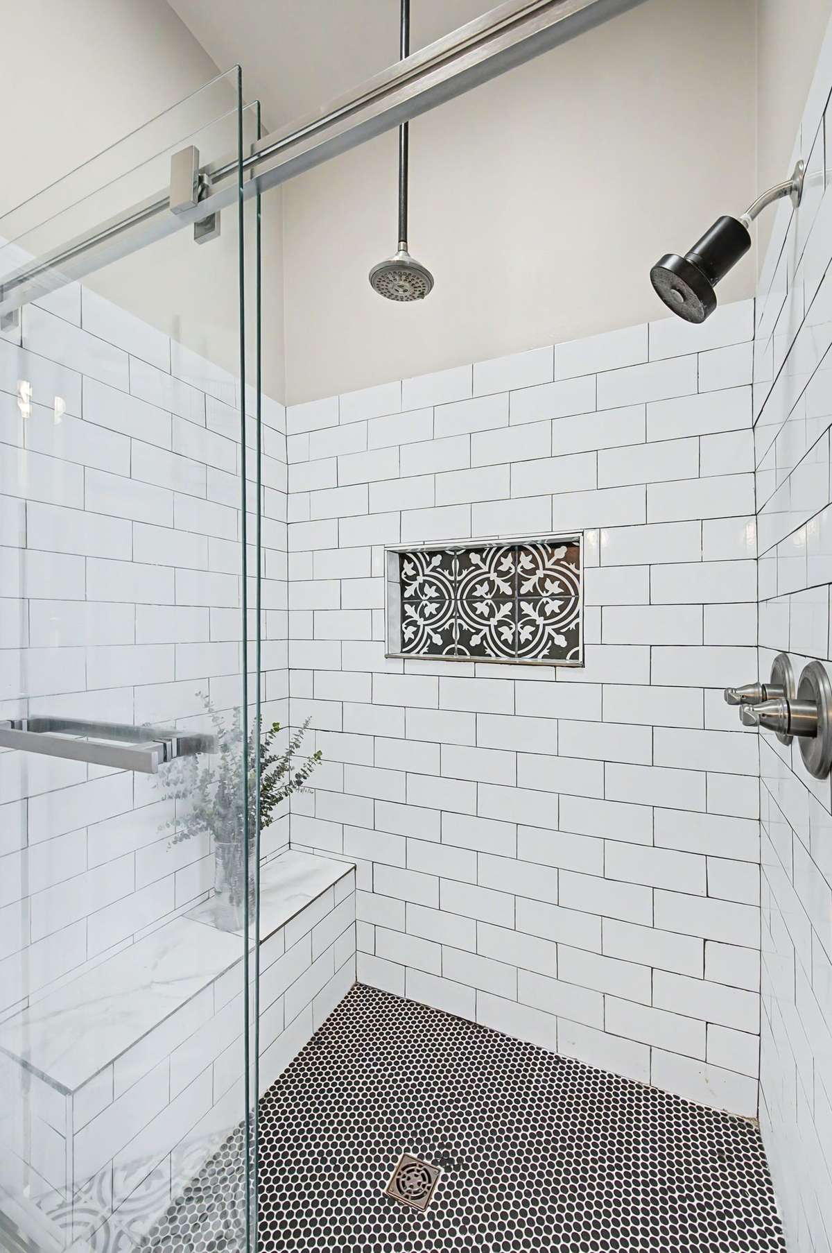 The large wak-in shower has custom tile and a built-in seat.