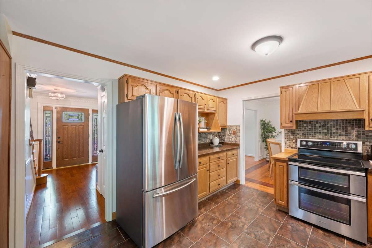 Stainless appliances remain. Kitchen countertops are granite overlay.