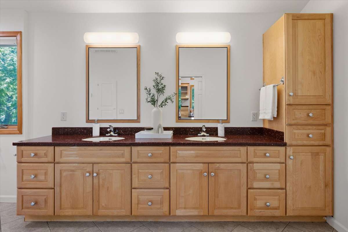 Custom cabinets with corona vanity tops. The right side bottom cabinet has a laundry basket pull out.