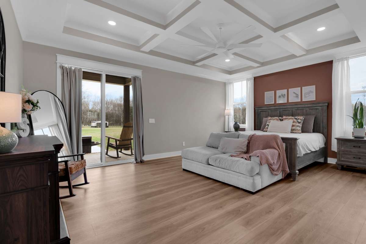 Primary Bedroom with coffered ceiling and beautiful flooring and walk out onto the large back porch