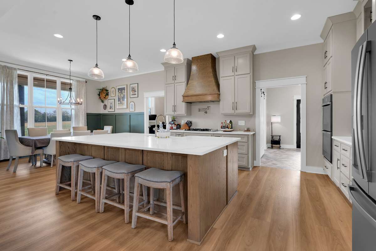 The gourmet kitchen is amazing with custom cabinets, stainless steel appliances, double ovens, a large island, and much more.  Look at all the seating at the island