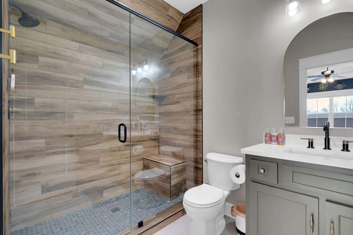 Full Bath in Bedroom 2 with walk in tile shower and custom cabinet