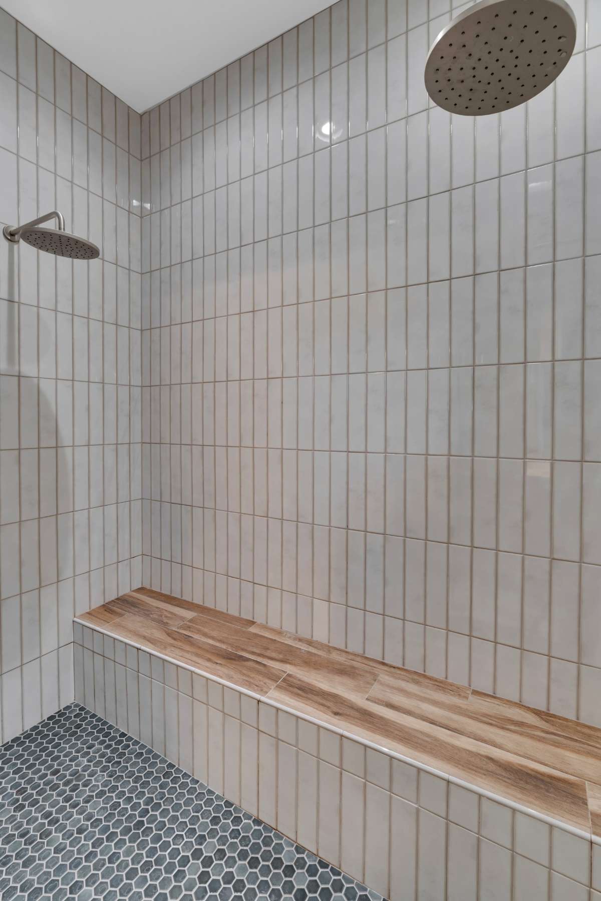 Primary tile shower with beautiful detail and seat and two rain heads