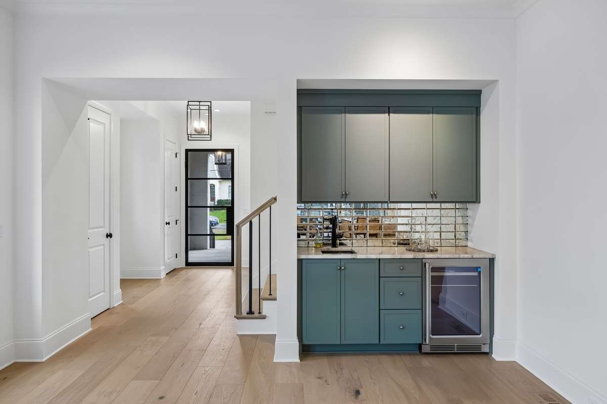 The wet bar adds a sophisticated touch with custom cabinetry and tilework, perfectly positioned for hosting, while the entire layout offers an easy, intuitive flow ideal for gatherings of any size.