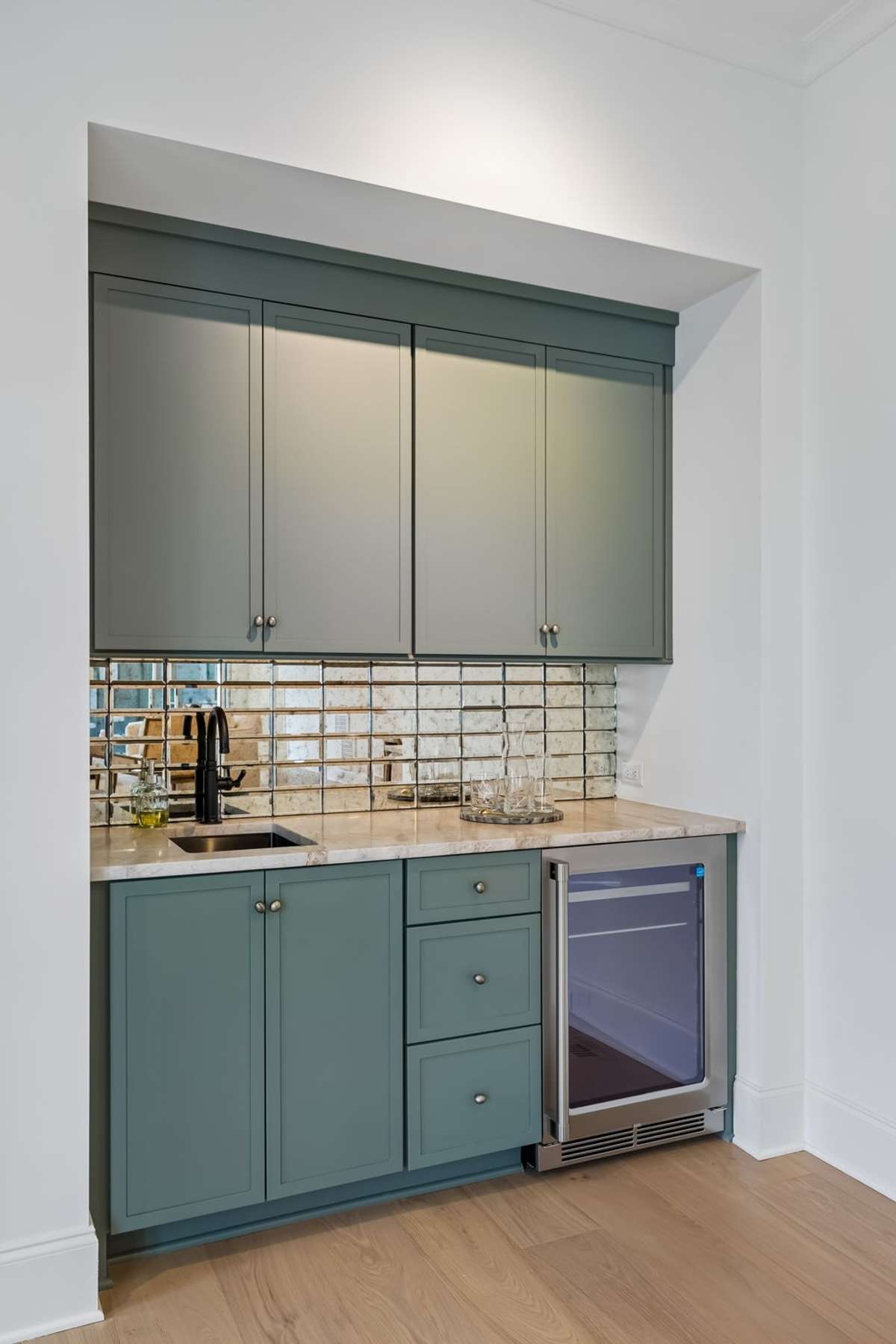 The wet bar adds a sophisticated touch with custom cabinetry and tilework, perfectly positioned for hosting, while the entire layout offers an easy, intuitive flow ideal for gatherings of any size.
