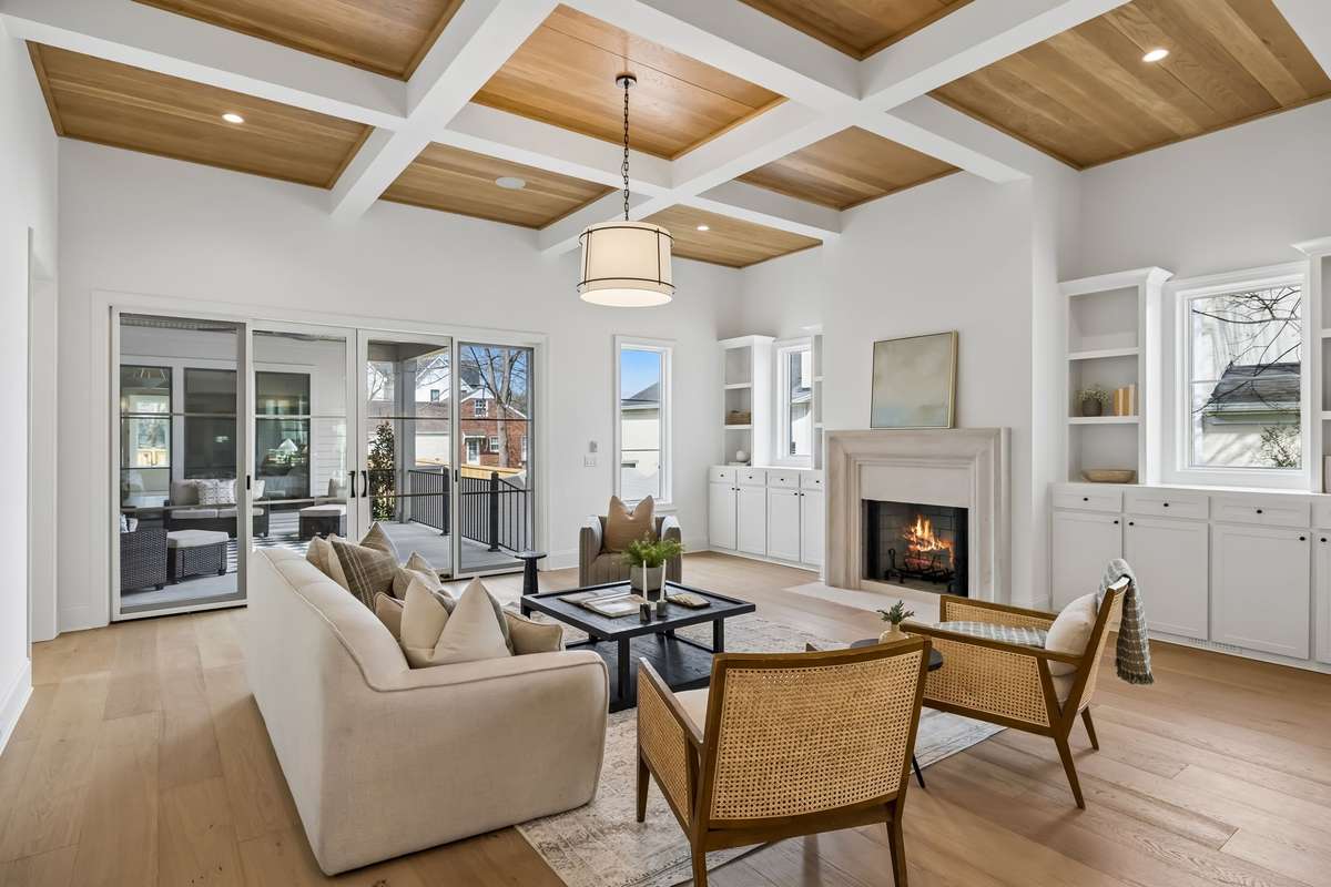 Light-filled living room with soaring ceilings and a stunning coffered wood detail that adds warmth and architectural interest.