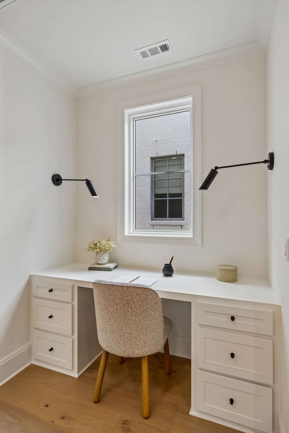 Thoughtfully designed built-in desk area with custom cabinetry and ample storage, perfect for working from home or everyday organization. Positioned by a window for natural light, this space offers both functionality and a clean aesthetic