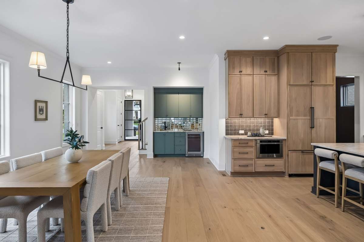 The wet bar adds a sophisticated touch with custom cabinetry and tilework, perfectly positioned for hosting, while the entire layout offers an easy, intuitive flow ideal for gatherings of any size.