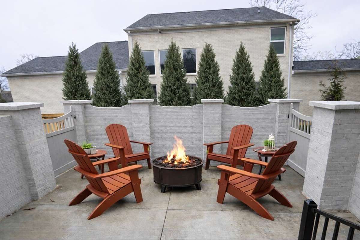 Spacious second patio area with room for a fire pit, grill, and dining table—perfect for entertaining. Imagine, with the help of AI, the backdrop of trees maturing into a lush, private backdrop that creates a secluded backyard setting