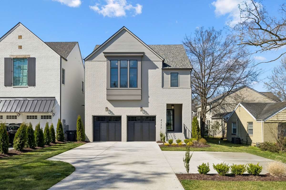 Stunning modern farmhouse exterior with timeless curb appeal, featuring painted brick and siding, clean architectural lines, and a welcoming covered entry. The home offers a spacious driveway, double garage, and thoughtfully designed landscaping with