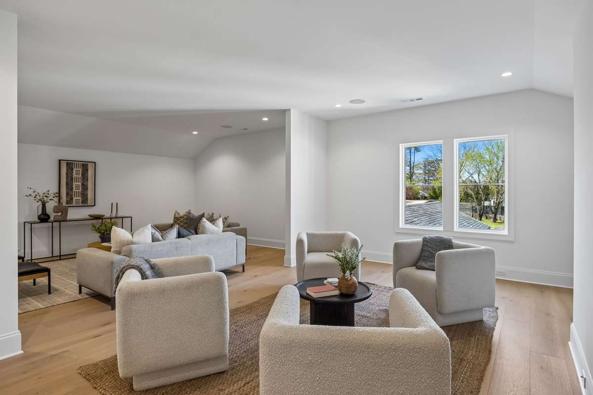 Bonus Room Three creates a cozy yet open retreat with abundant natural light and a comfortable seating area, ideal for a secondary living space, reading nook, or work-from-home setup.