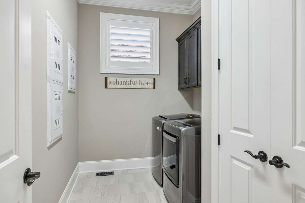 Laundry room with built-in cabinets and storage closet.