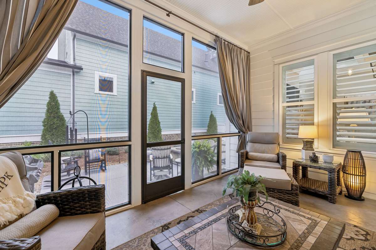 Screened porch with custom drapes and coated concrete flooring.