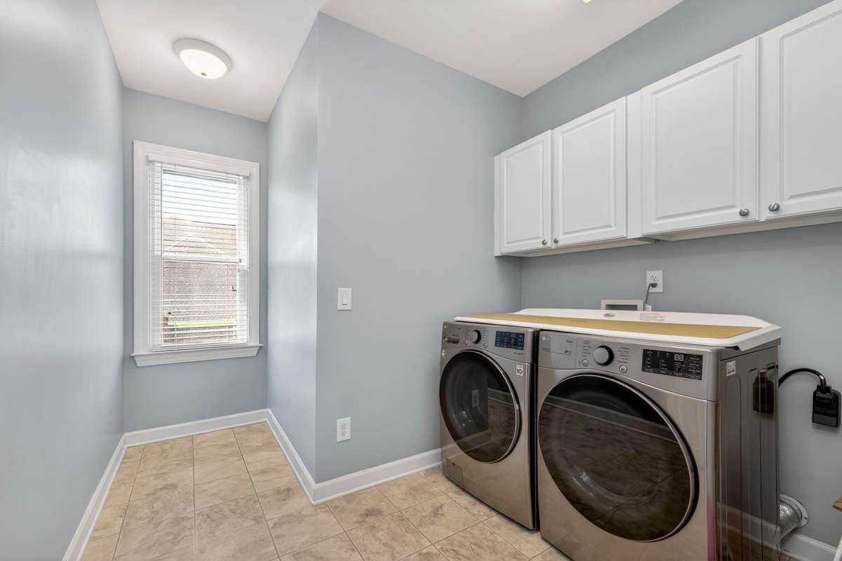 Even the laundry room is doused in sunlight, with extra storage cabinets above the washer/dryer.