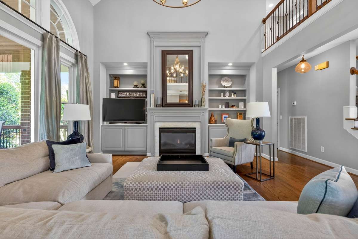 A spacious living area provides a cozy entertaining space, featuring a gas fireplace, custom built-ins, vaulted ceilings, and a wall of windows providing endless natural light.