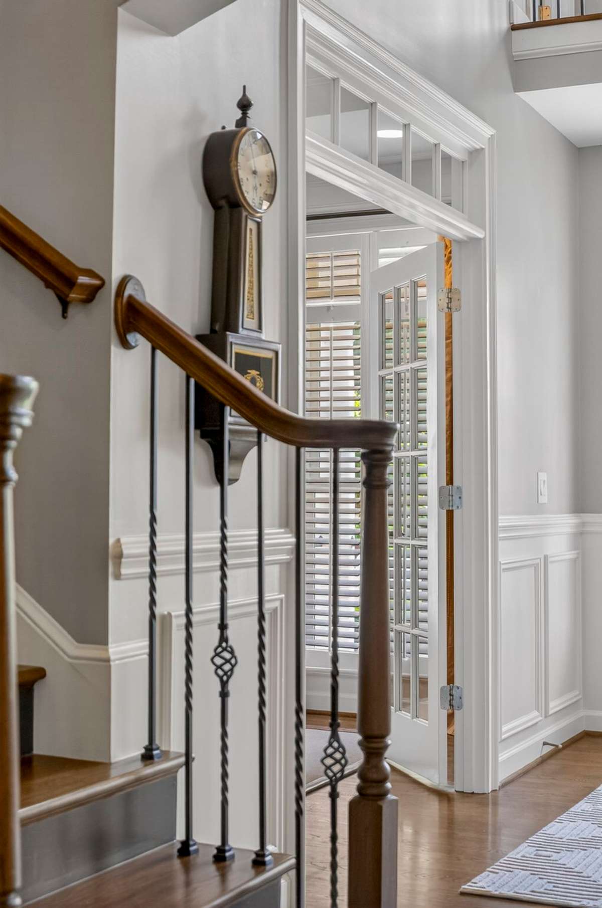 One of two staircase with hardwood stair treads and wrought iron rails leading to the second level