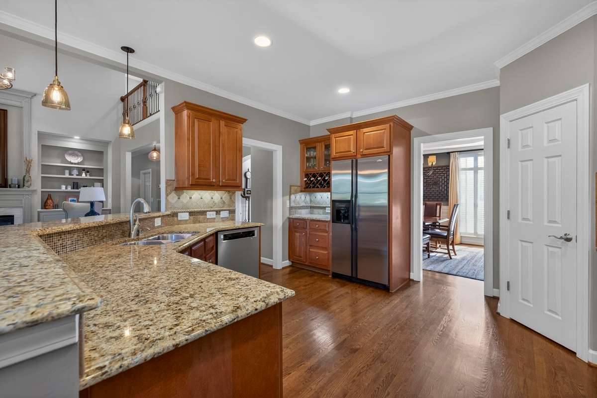 Granite countertops blend seamlessly with the wooden cabinets and all-stainless steel appliances.