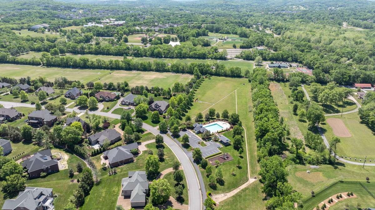 Aerial view of the community showcasing scenic green space, walking trails, and resort-style amenities - all nestled within a beautifully maintained neighborhood.