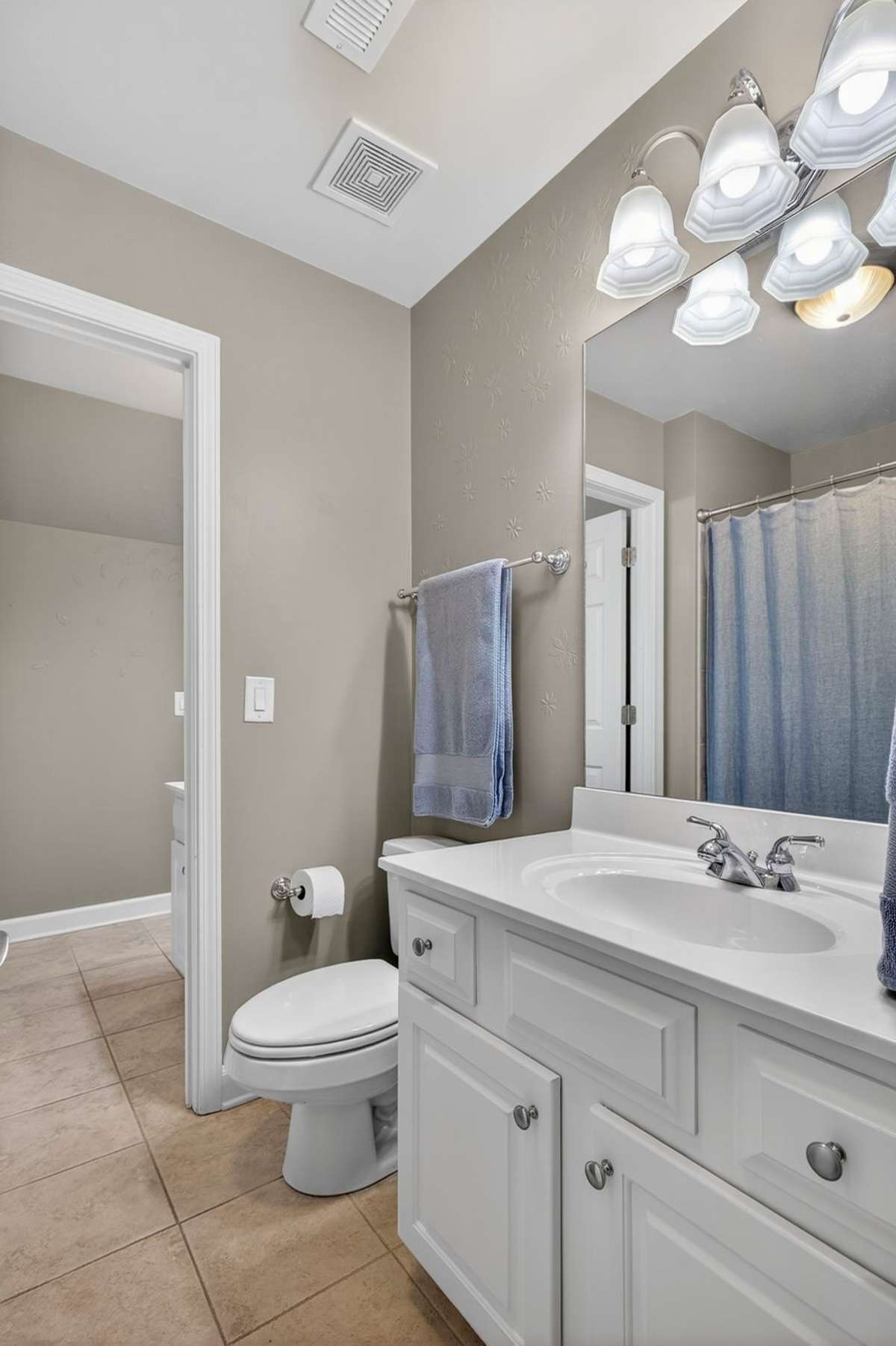 Bedroom three connects to the jack-and-jill bathroom with a generous vanity and fresh paint.