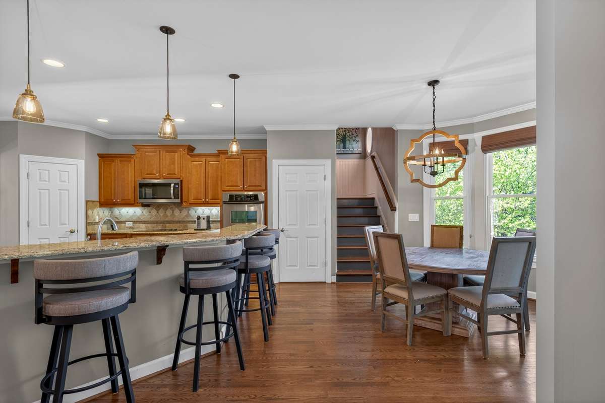 This practical floor plan allows for bar seating and a light-filled breakfast nook. An enclosed stairwell leads to the garage/flex room, while a second stairway leads to the upper level. Brand new fixtures and recessed lighting complement the space.