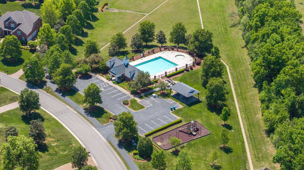 Resort-style community amenities featuring a sparkling pool, pavilion, playground, and scenic walking trails - all set amidst beautifully maintained green space.