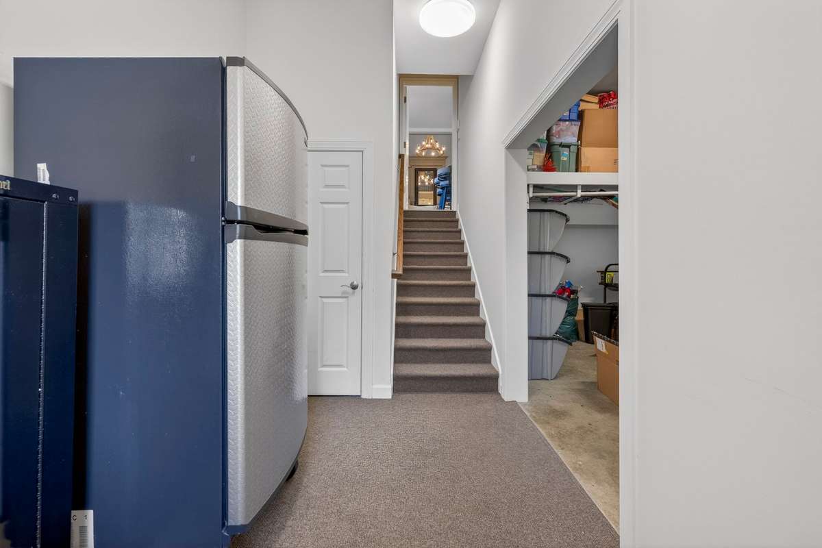Step down a short flight of stairs into the 3-car garage, where an extended hallway opens to the driveway - offering excellent potential for a spacious mudroom.  A walk out door into the side yard.