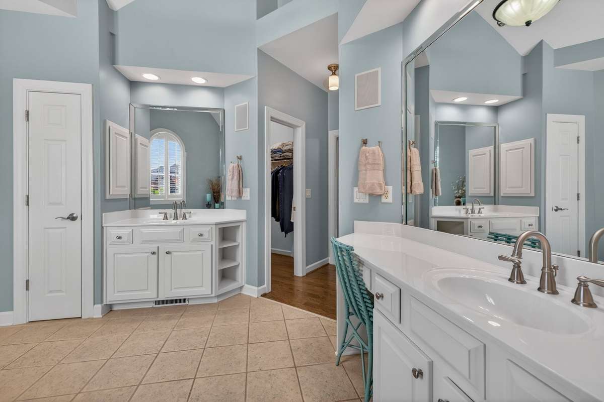 This angle provides a view of double sinks with separate vanity, double walk-in closets, and an additional linen closet.