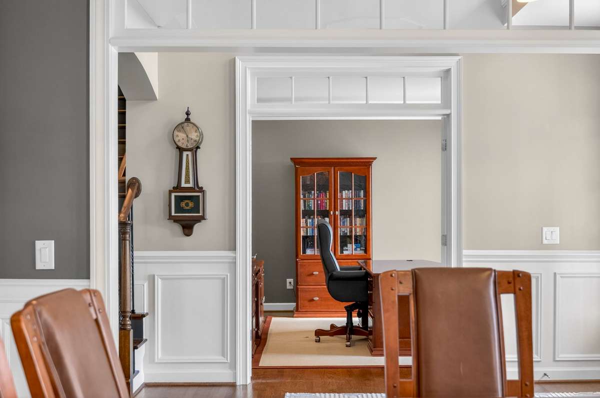 A view from the formal dining room through the foyer and into the home office, accentuated by picture frame molding and natural light.