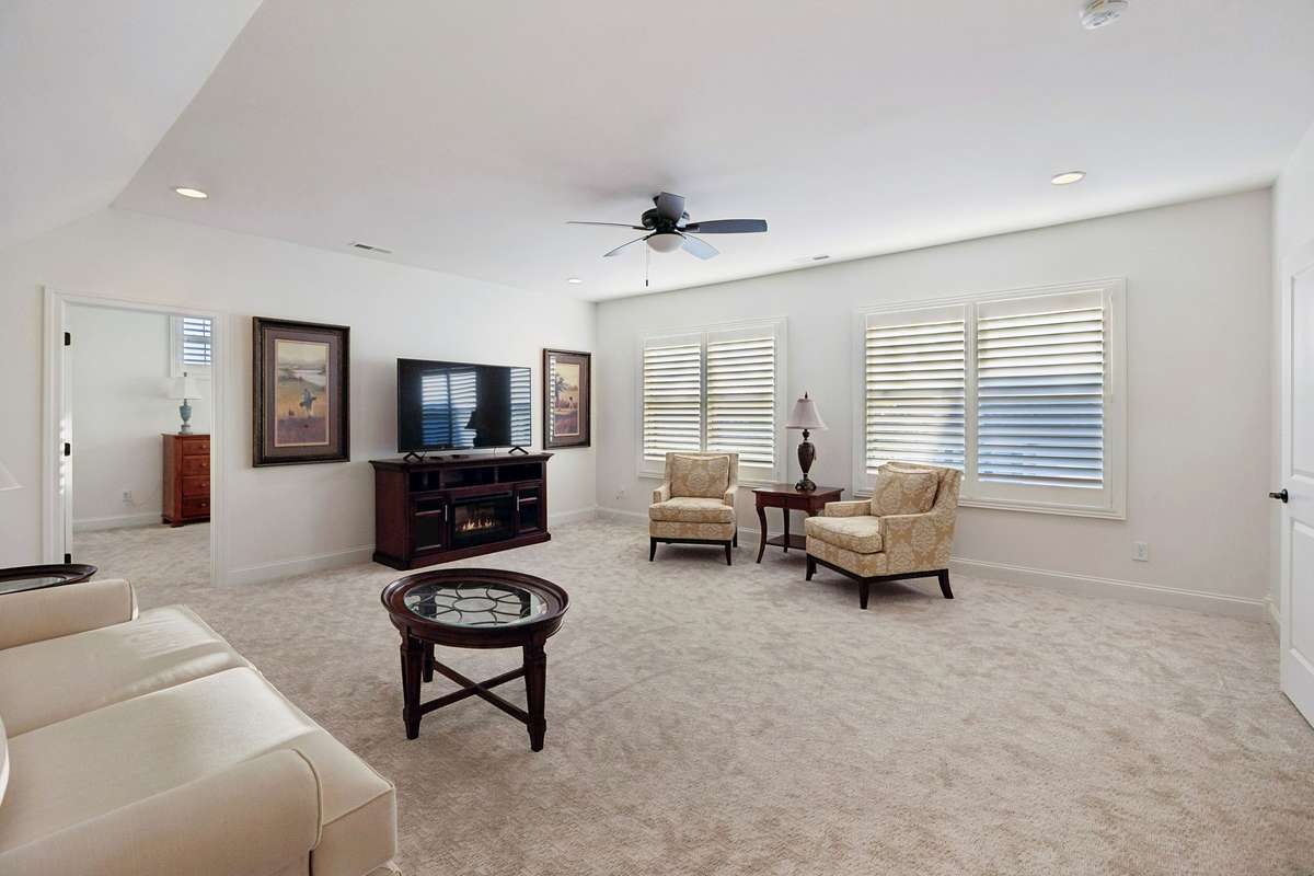 The upstairs features a large carpeted bonus room with plenty of natural light.