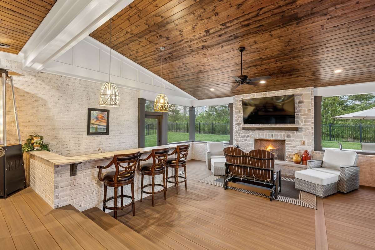 One of the home's best features is the covered/screened back porch, complete with a kitchen, fireplace, entertaining area, and hot tub.