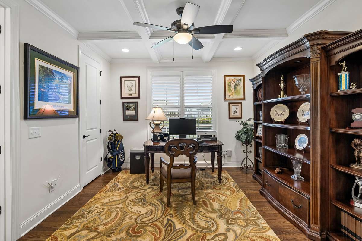 This bedroom located on the main level includes coffered ceilings and natural light, plus a Jack-and-Jill bathroom.