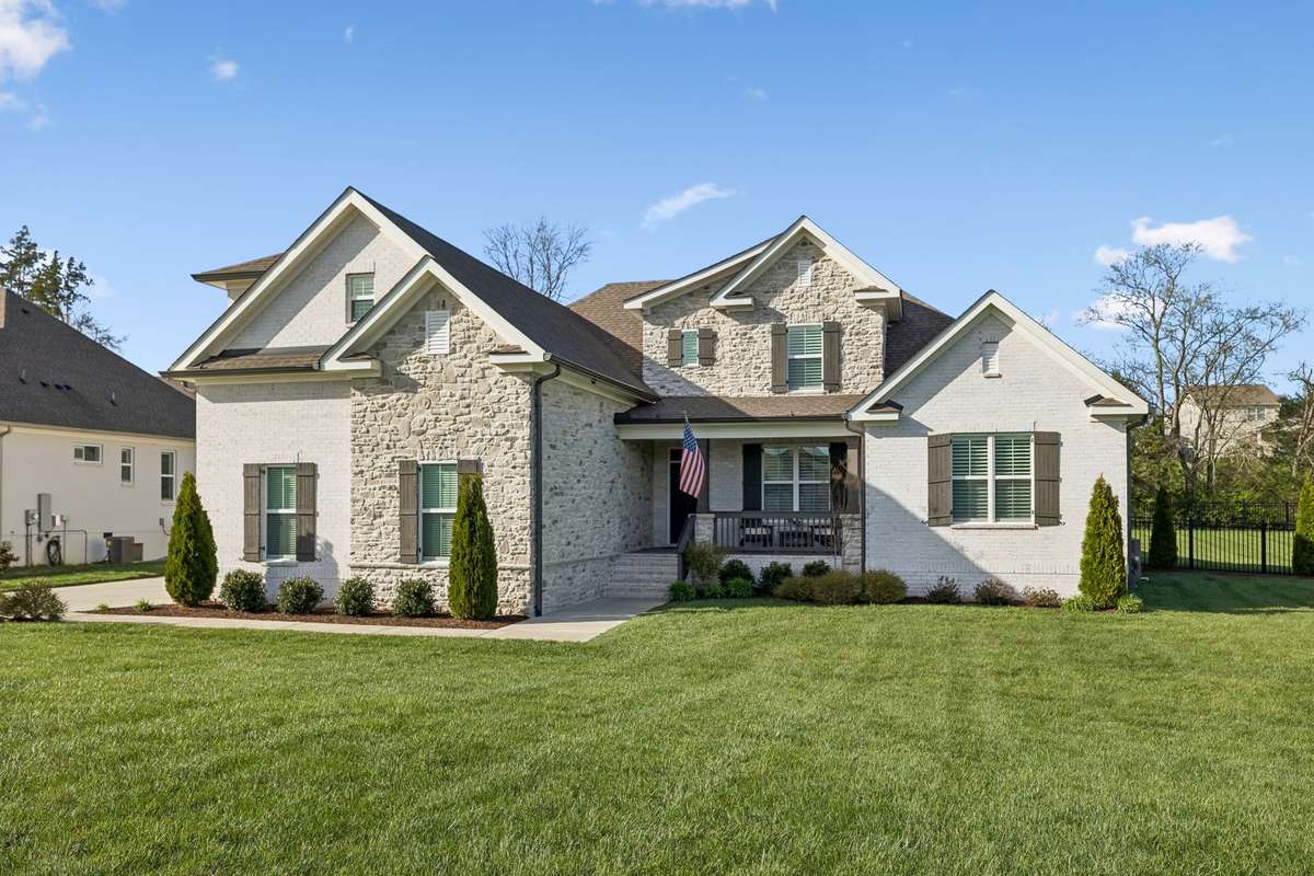 The manicured lot features thoughtful landscaping and uplighting.