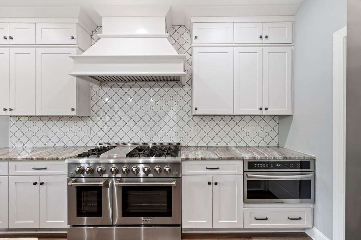 View showing Large Stove in Kitchen with Vent and  Microwave on end