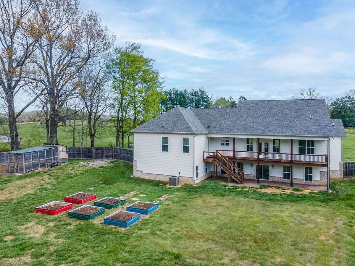 Back yard featuring the raised beds for planting your garden this year.  This picture shows how large the home really is with the basement area (which is roughed in for 2514 more sq. ft.)